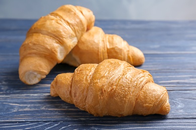 Tasty croissants on wooden table