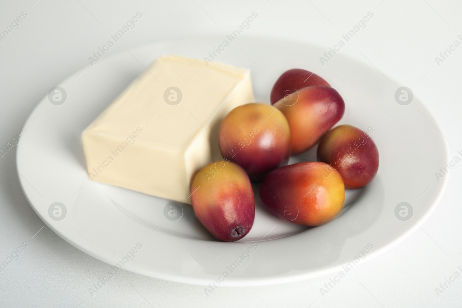 Image of Plate with butter and palm oil fruits isolated on white