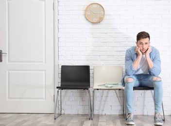 Photo of Young man waiting for job interview, indoors