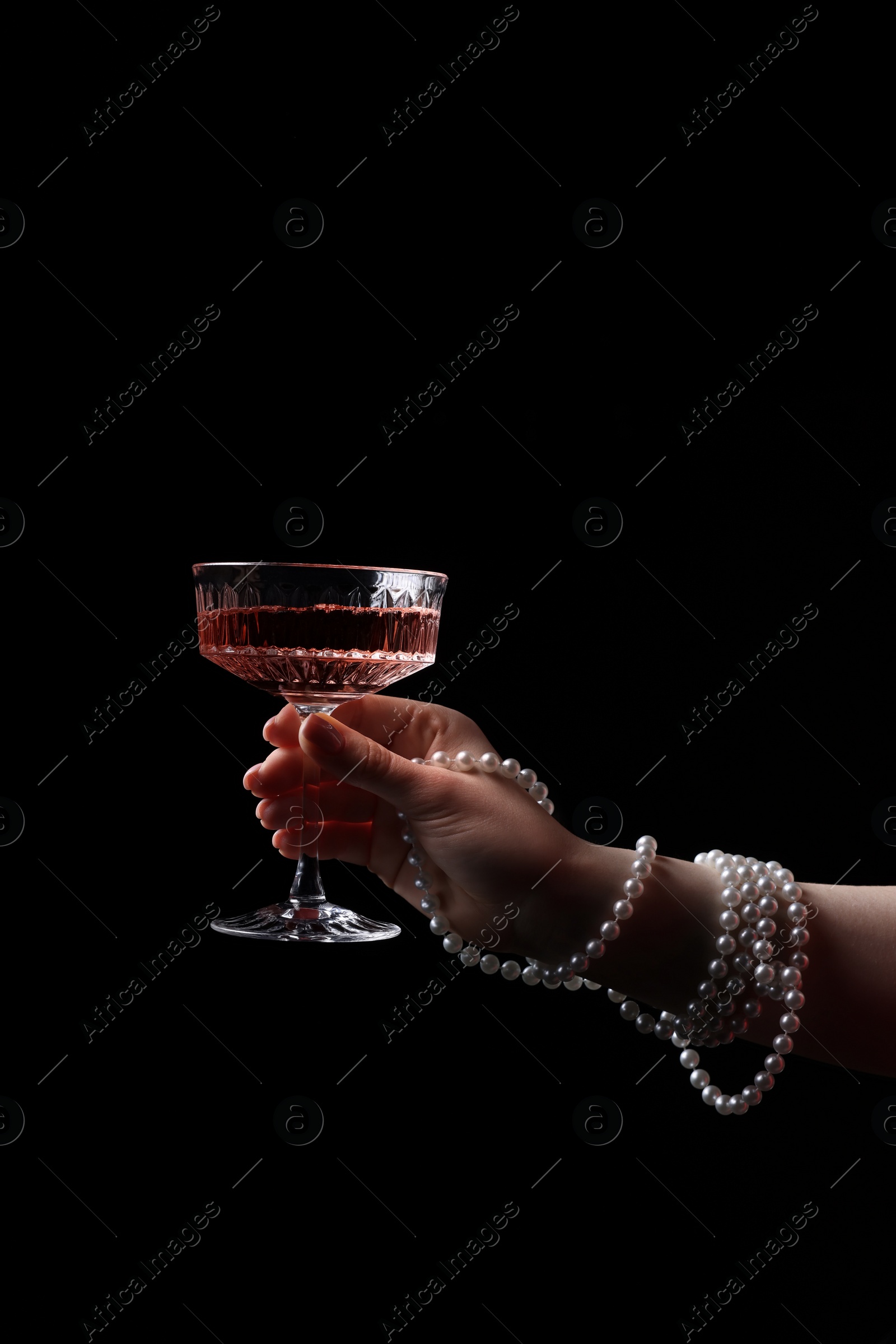 Photo of Fashionable photo of woman with glass of delicious wine against black background, closeup