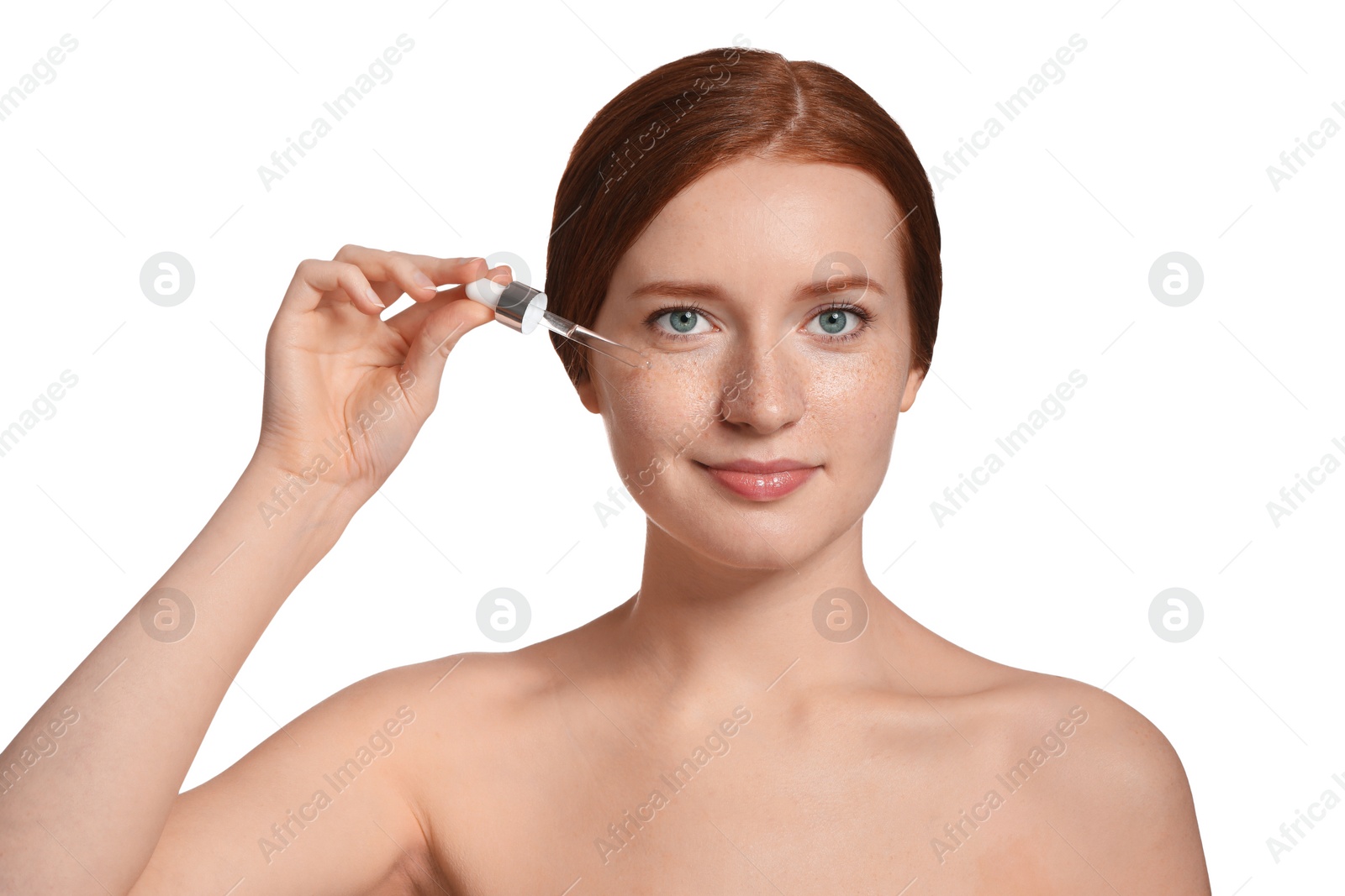 Photo of Beautiful woman with freckles applying cosmetic serum onto her face on white background