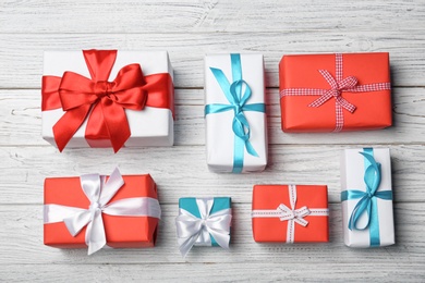 Photo of Flat lay composition with beautiful gift boxes on wooden background