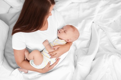 Photo of Mother with her sleeping baby in bed at home