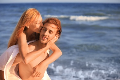 Photo of Young lovely couple on beach at sunset