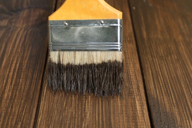 Photo of Applying wood stain onto wooden surface, closeup