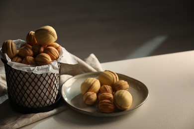 Photo of Delicious homemade walnut shaped cookies with tasty filling on beige table