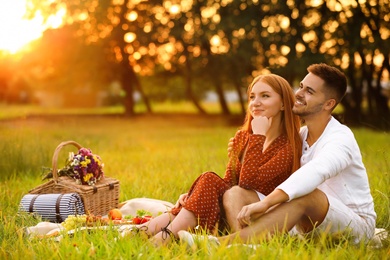 Photo of Happy young couple having picnic in park