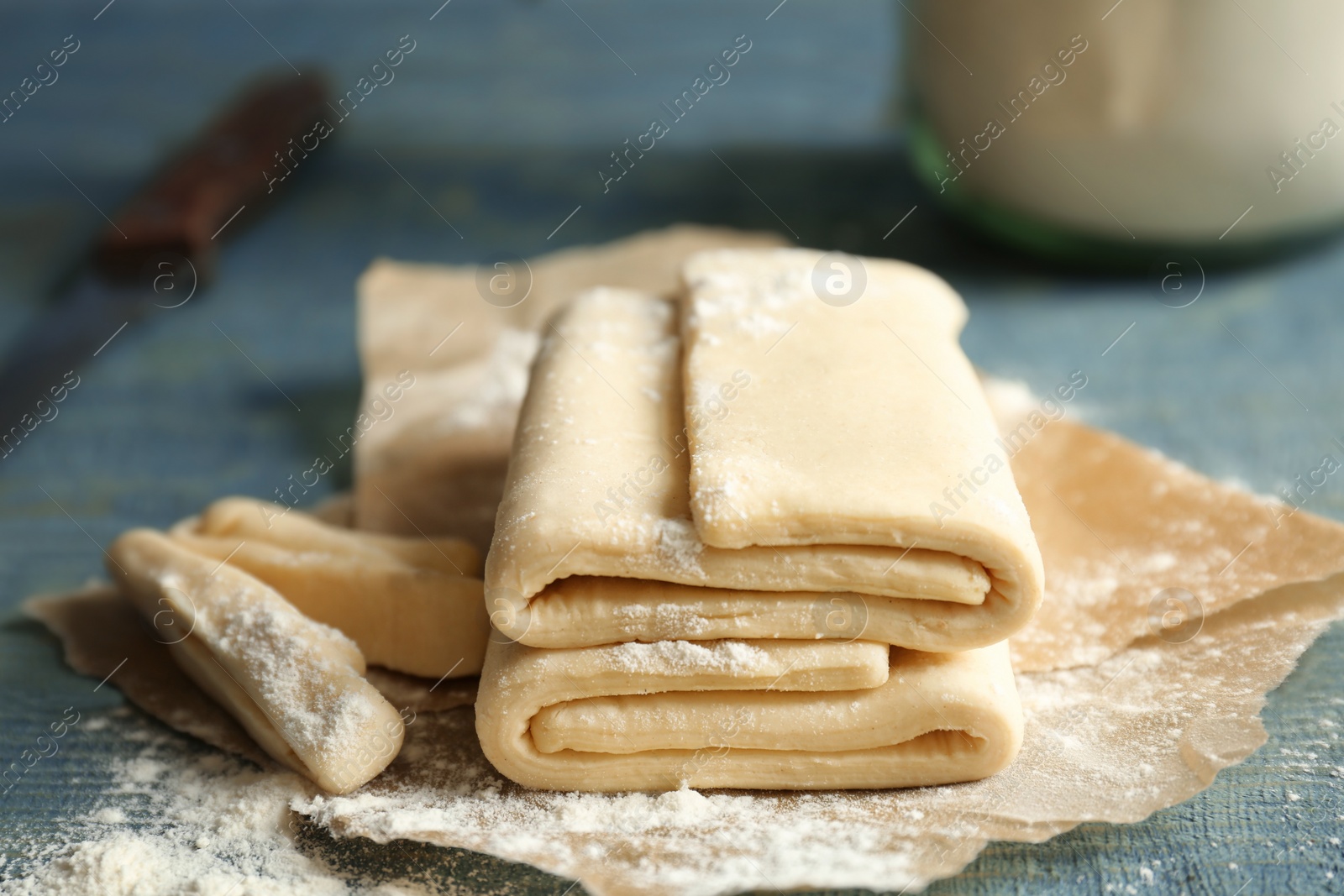 Photo of Fresh raw dough on parchment paper, closeup