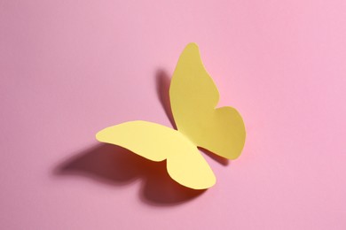 Photo of Yellow paper butterfly on pink background, top view