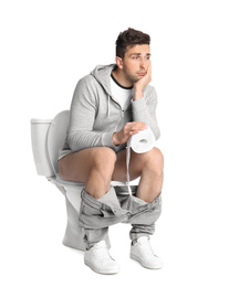 Photo of Emotional man with paper roll sitting on toilet bowl, white background
