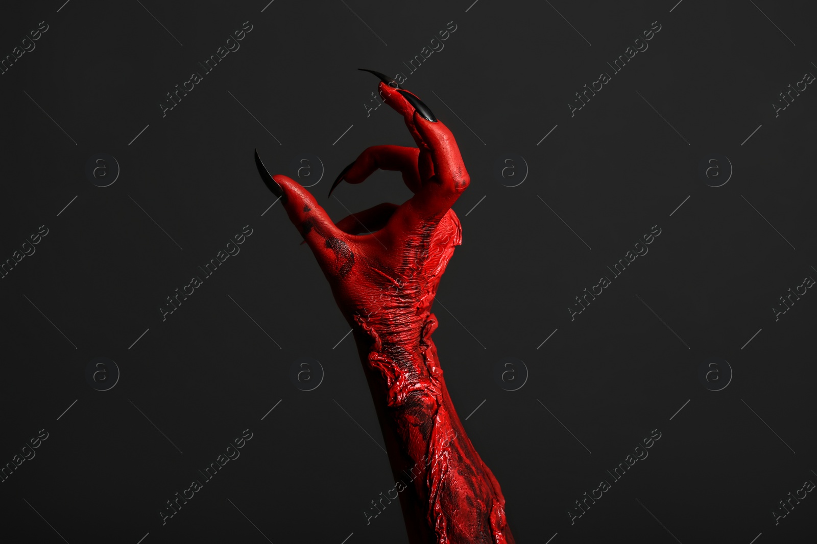 Photo of Scary monster on black background, closeup of hand. Halloween character