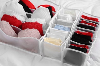 Photo of Organizer with stylish women's underwear on bed