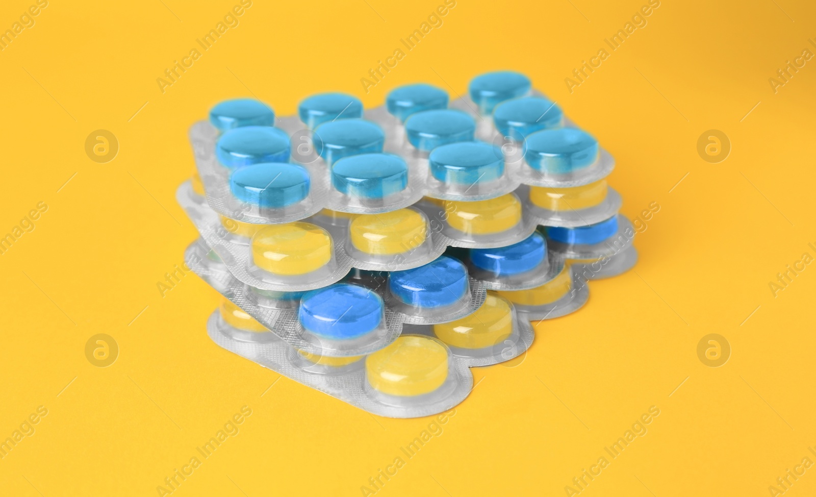 Photo of Blisters with cough drops on yellow background, closeup