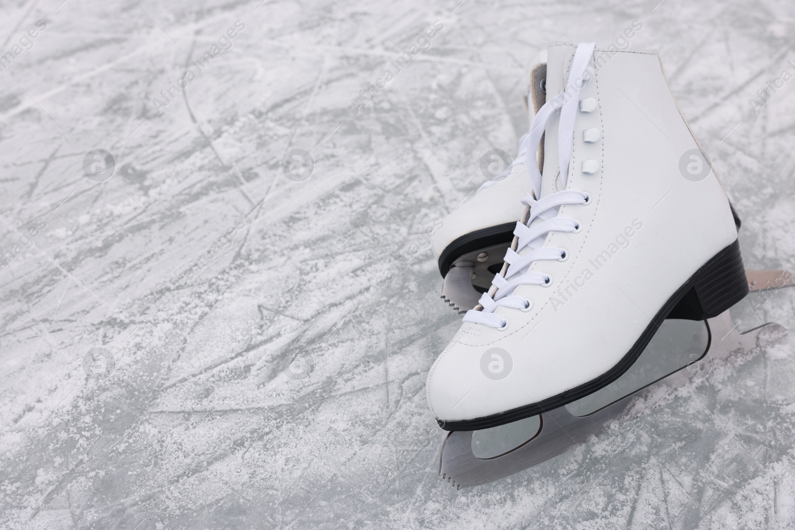 Photo of Pair of figure skates on ice, space for text