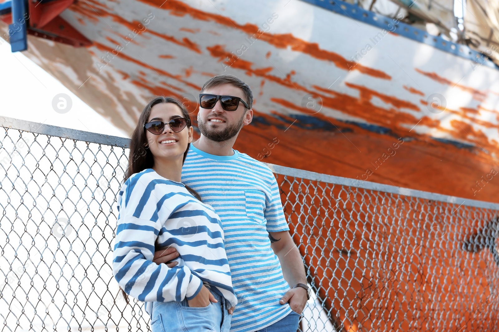 Photo of Young hipster couple in stylish jeans on pier