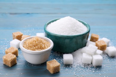 Different types of sugar on light blue wooden table