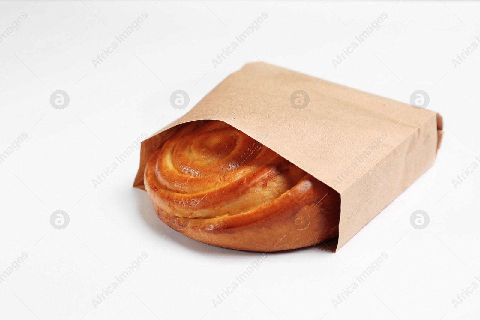 Photo of Paper bag with bun on white background. Space for design