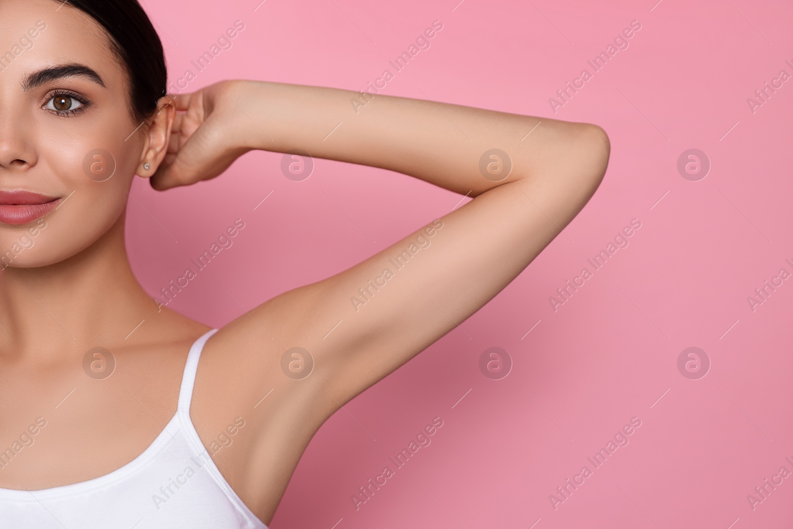 Photo of Young woman showing smooth skin after epilation on pink background, closeup. Space for text