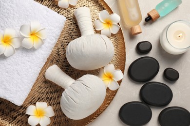 Photo of Spa bags, stones and orchid flowers on beige marble table, flat lay