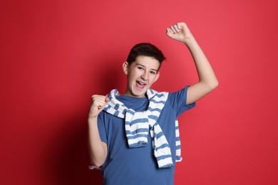 Portrait of happy teenage boy on red background