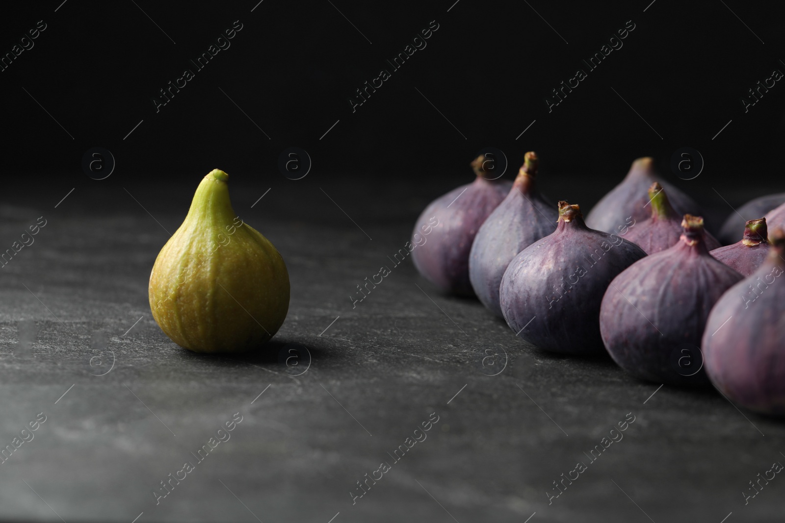 Photo of Green and purple ripe figs on black slate table, closeup