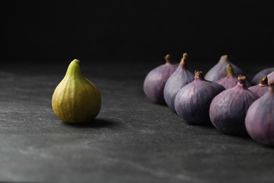 Photo of Green and purple ripe figs on black slate table, closeup