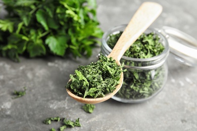 Photo of Fresh and dried parsley on grey table, closeup