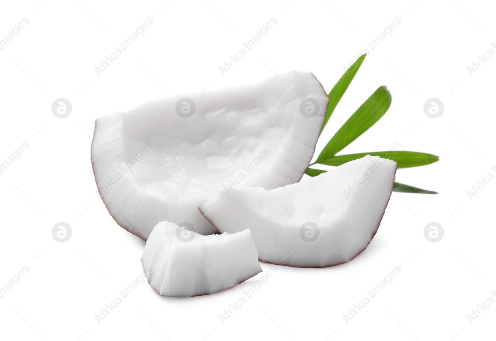 Photo of Pieces of tasty ripe coconut with palm leaf on white background