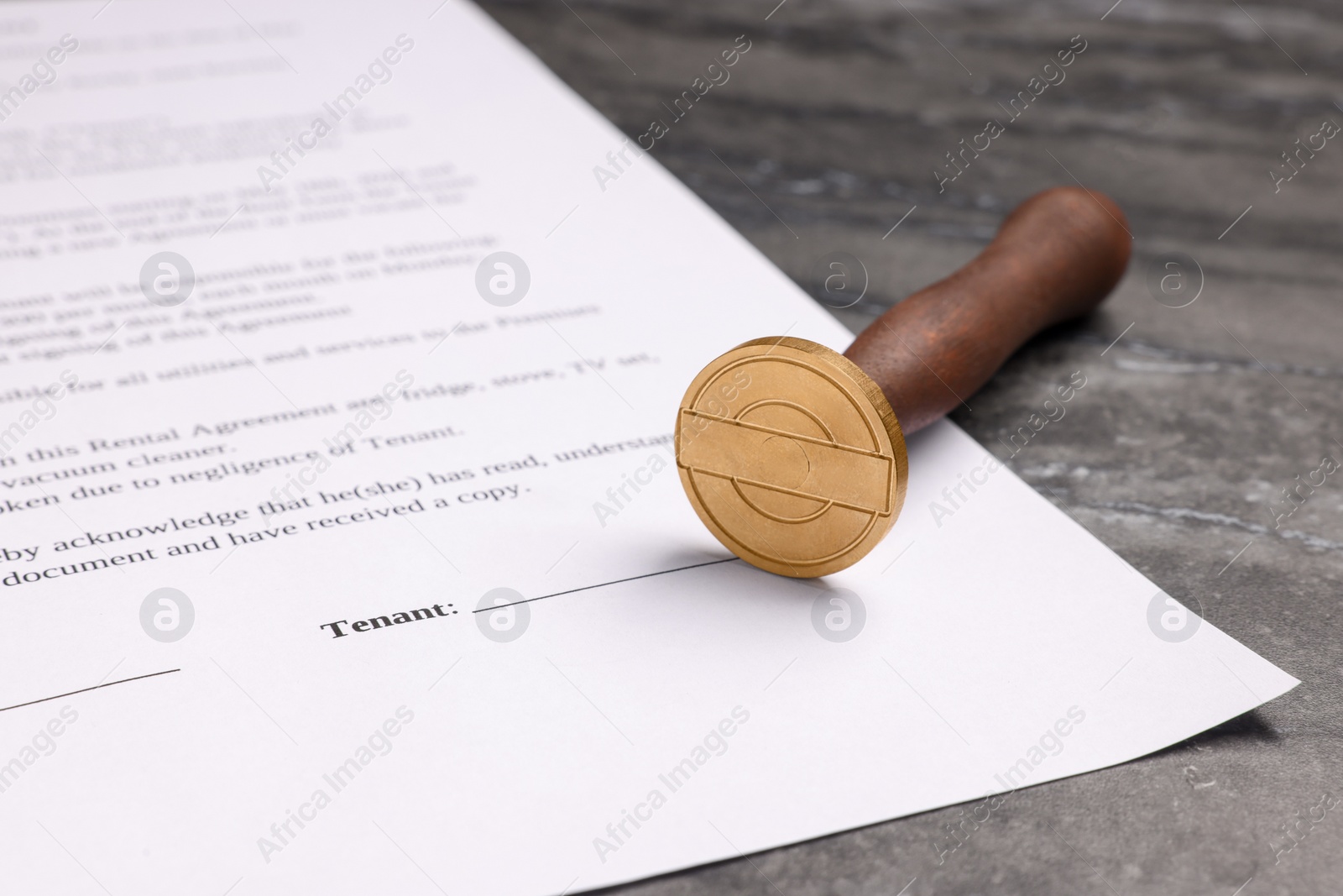 Photo of One stamp tool and document on grey marble table, closeup