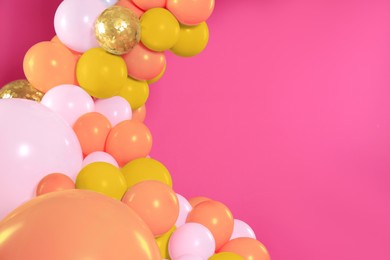 Image of Balloon garland on pink background. Festive decor