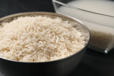 Grains and rice water on black table, closeup