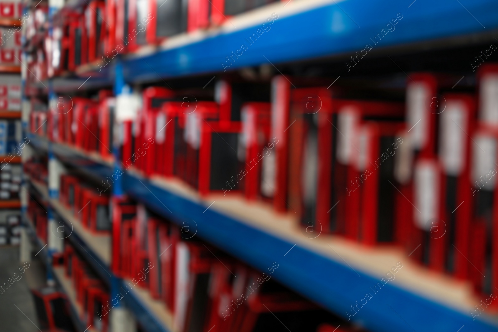 Photo of Blurred view of shelving unit with merchandise in modern wholesale shop