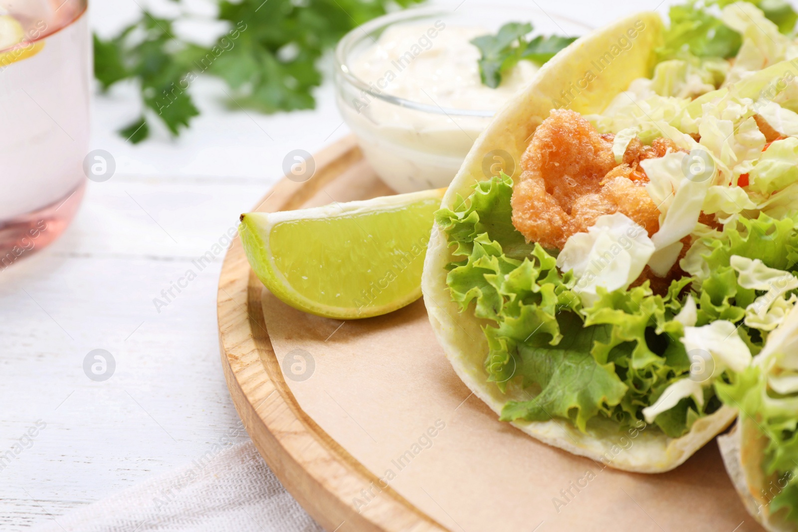 Photo of Delicious fish tacos served on white wooden table, closeup