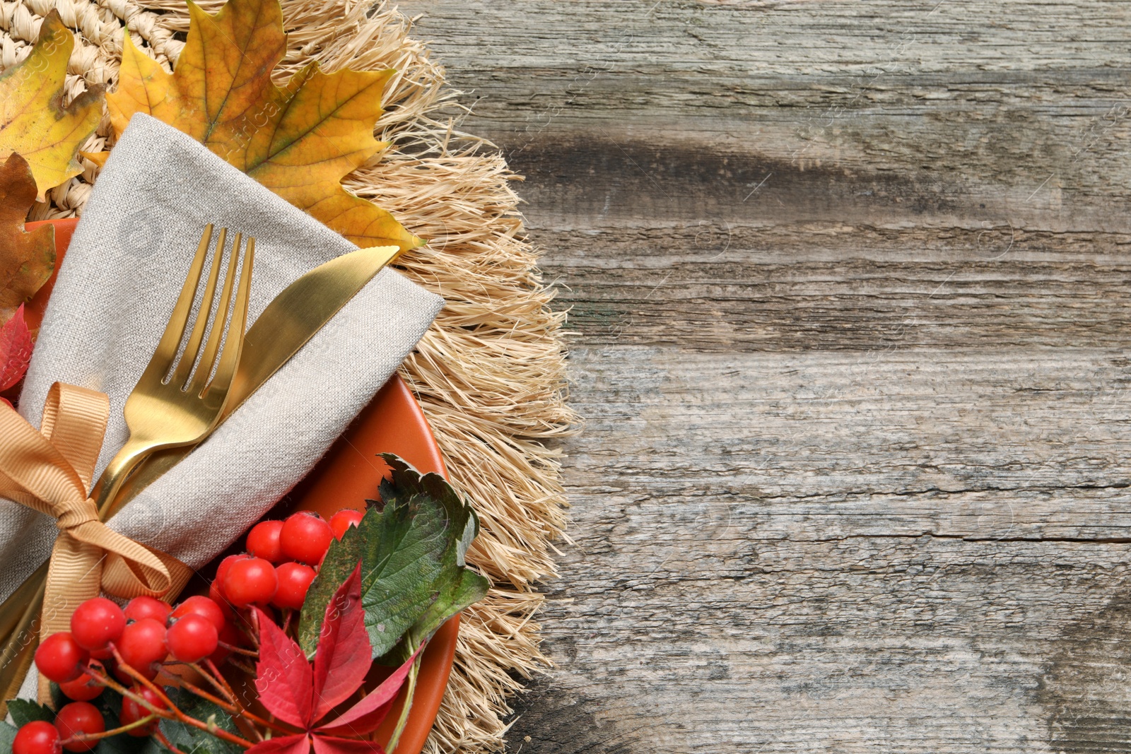 Photo of Festive table setting with autumn decor on wooden background, top view. Space for text