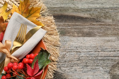 Photo of Festive table setting with autumn decor on wooden background, top view. Space for text