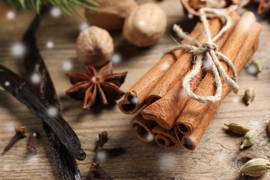 Image of Different spices on wooden table, closeup. Cinnamon, cloves, anise, cardamom, vanilla, nutmegs