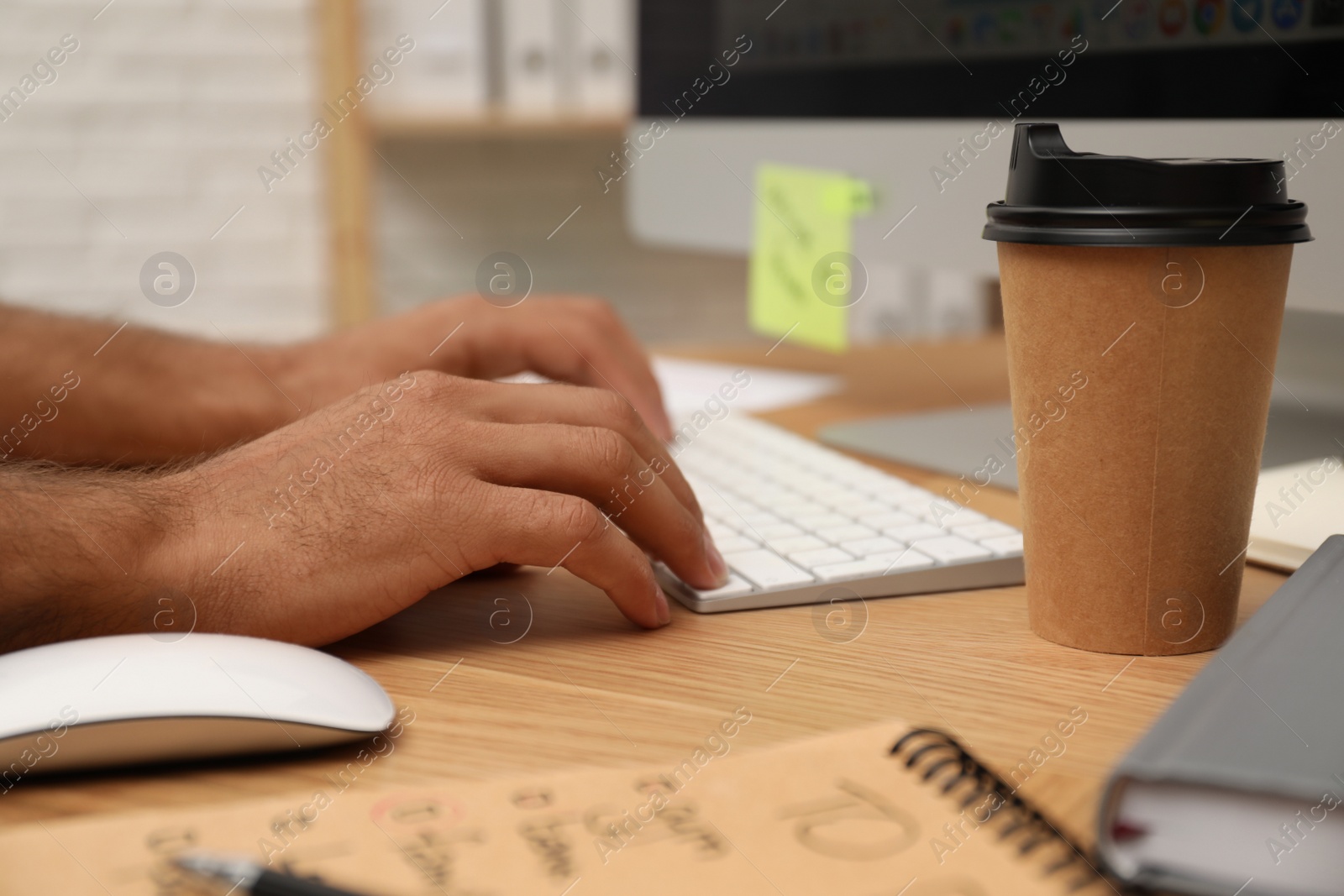 Photo of Man using computer at table in office, closeup