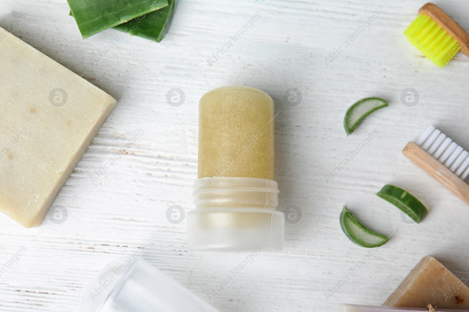 Photo of Flat lay composition with natural crystal alum deodorant on white wooden table