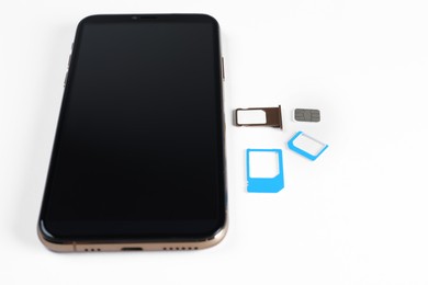 Photo of SIM cards and mobile phone on white table