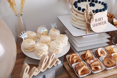 Baby shower party. Different delicious treats and decor on wooden table