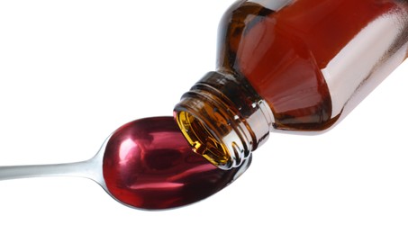 Pouring cough syrup into spoon on white background, top view