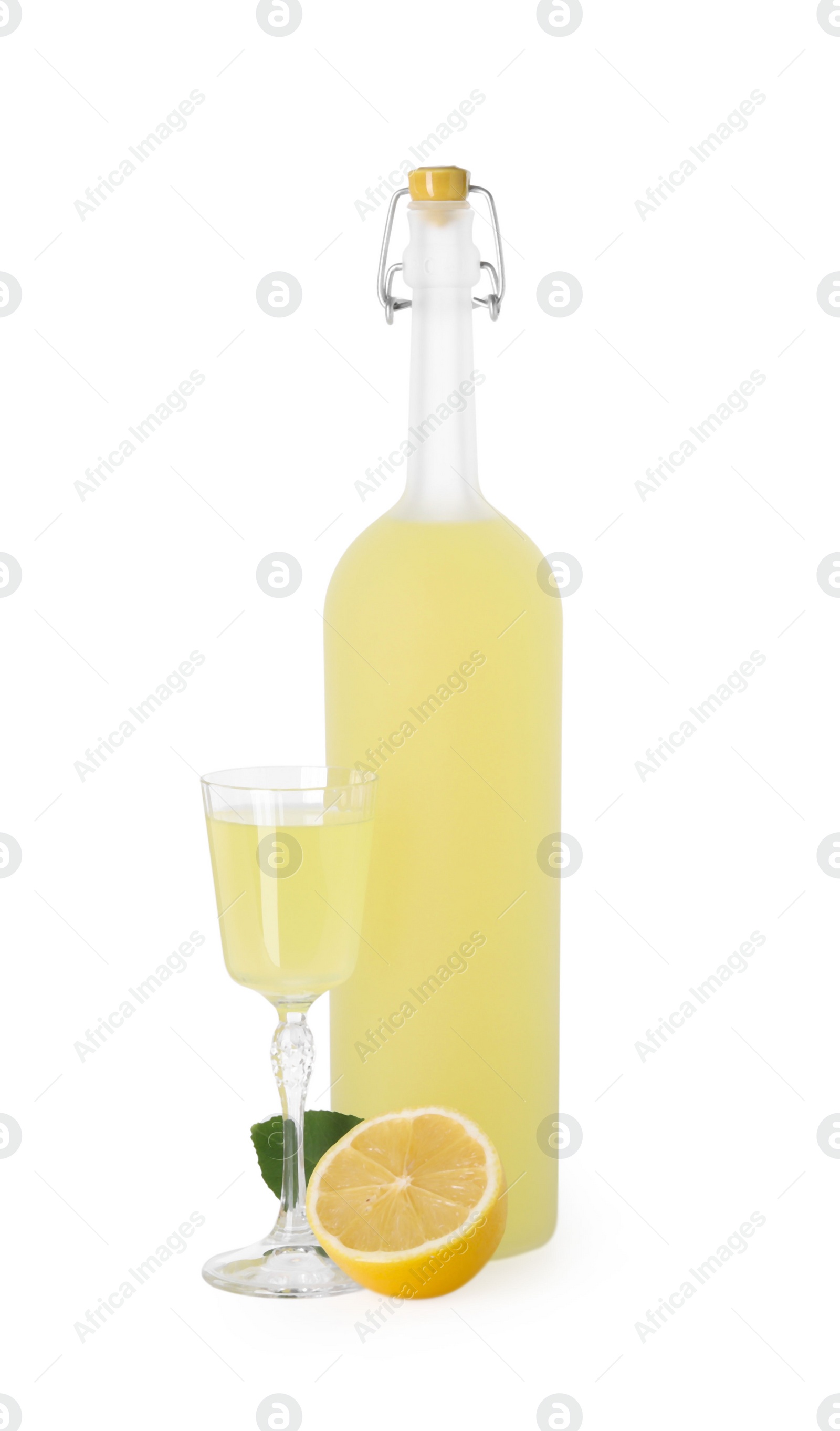 Photo of Tasty limoncello liqueur, half of lemon and green leaf isolated on white