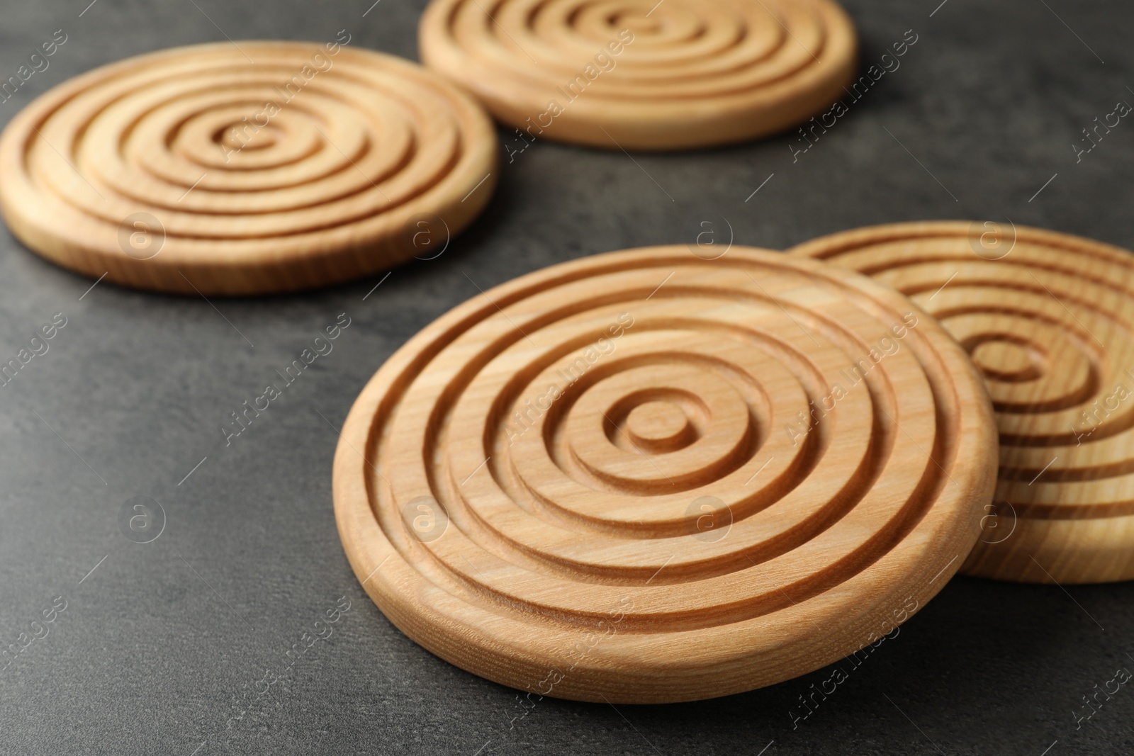 Photo of Stylish wooden cup coasters on dark grey table