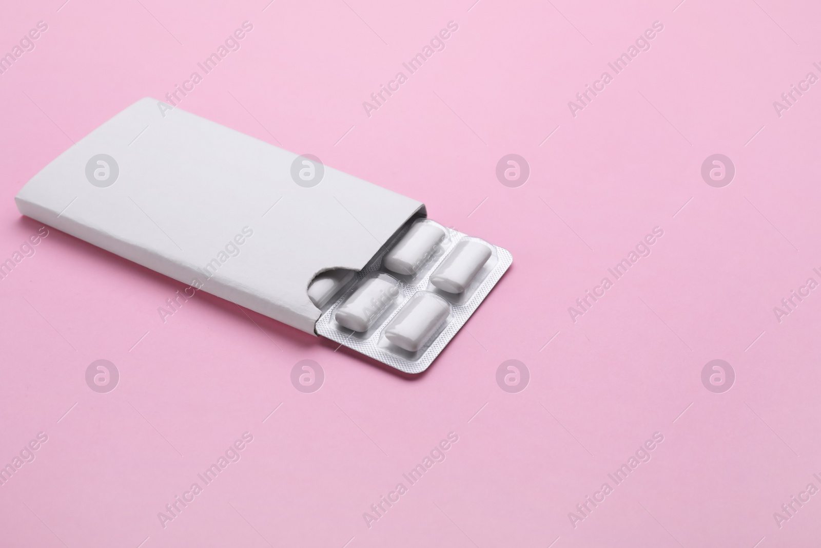 Photo of Blister with chewing gums on pink background. Space for text