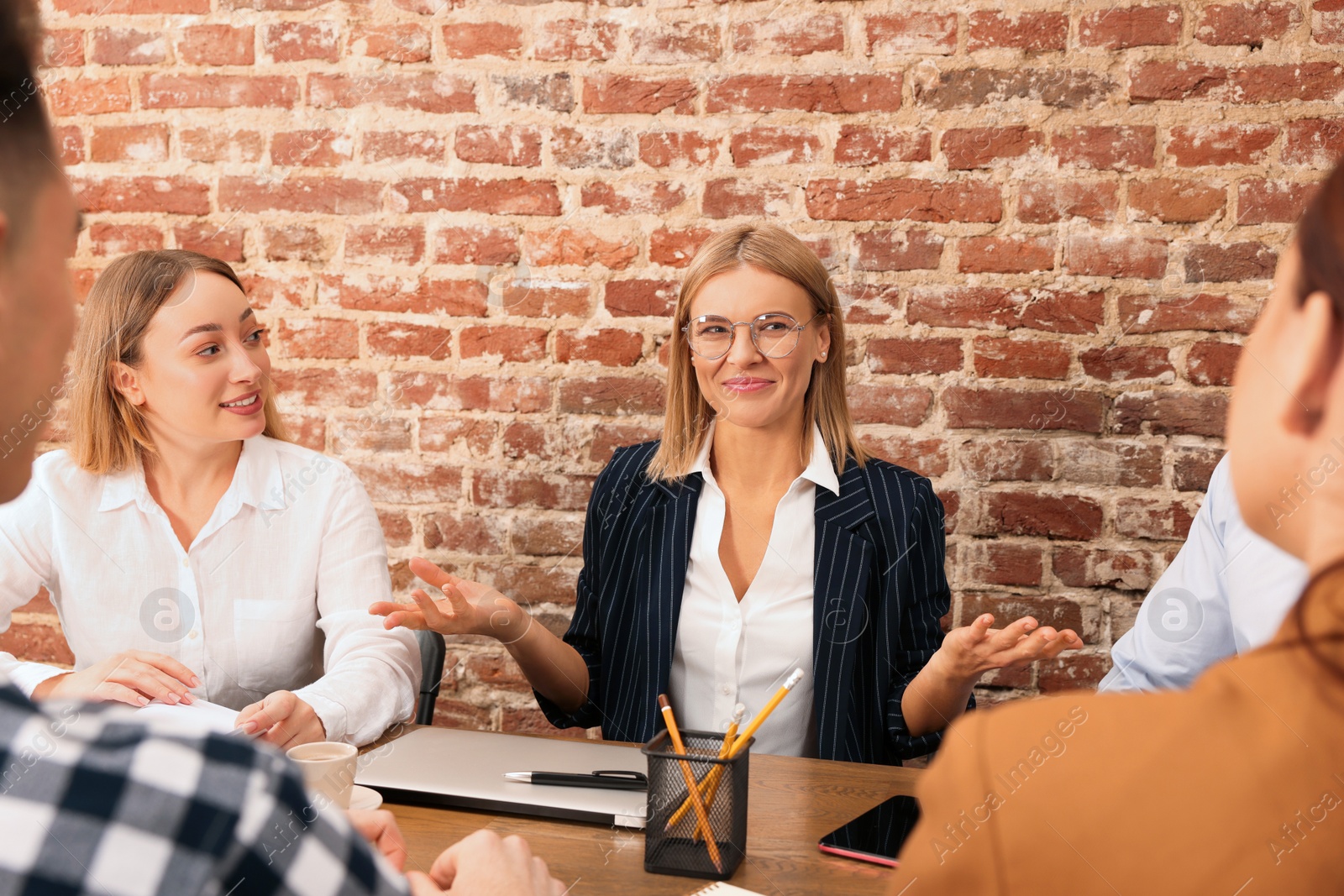 Photo of Businesswoman having meeting with her employees in office. Lady boss