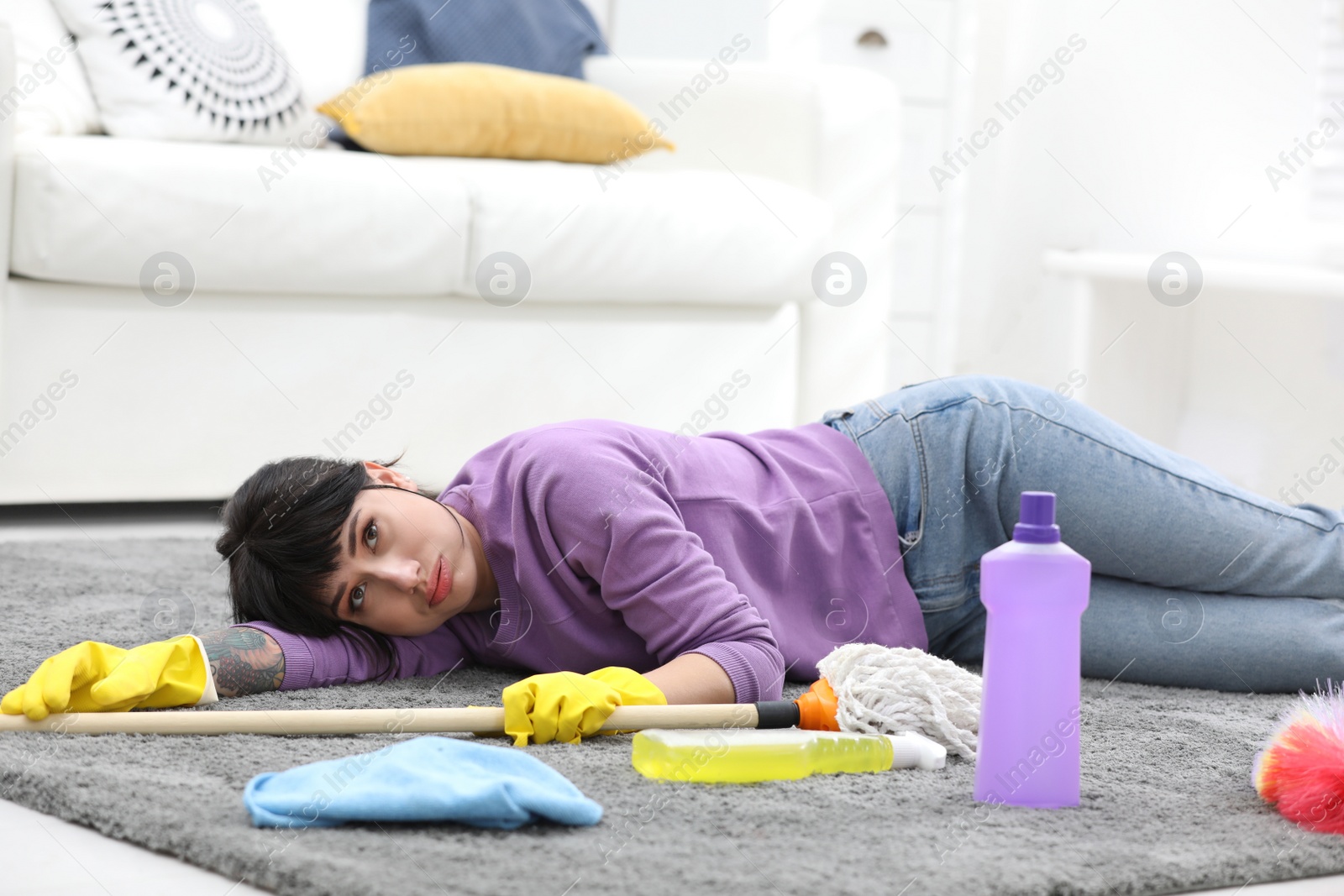 Photo of Lazy woman procrastinating while cleaning at home