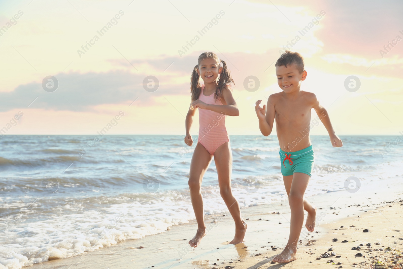 Photo of Cute children enjoying sunny day at beach. Summer camp