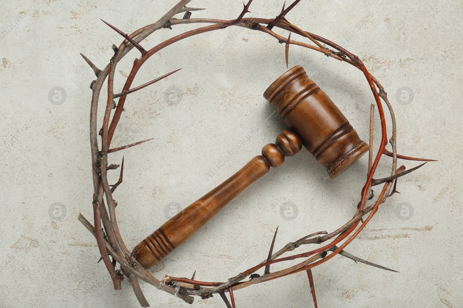 Photo of Crown of thorns and judge gavel on light grey table, flat lay