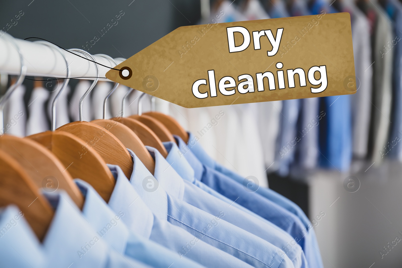 Image of Rack with clean clothes on hangers after dry-cleaning indoors