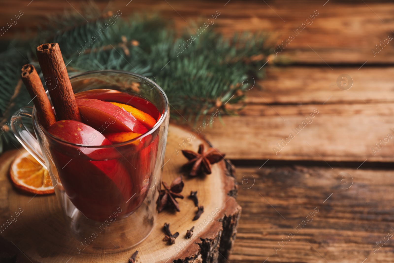 Photo of Tasty aromatic mulled wine on wooden table. Space for text